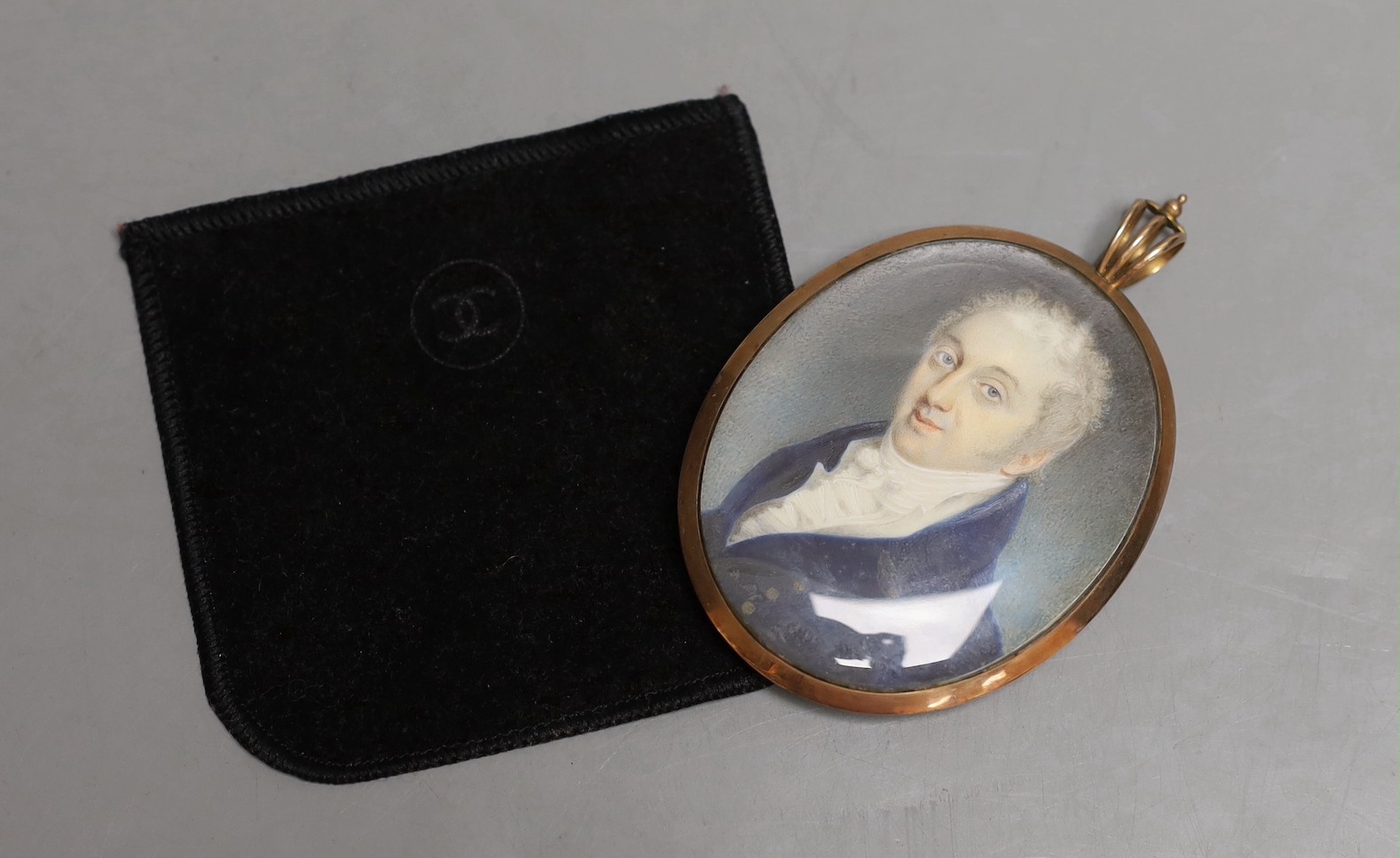 A late Georgian portrait miniature of a gentleman, with memorial hair plaque and monogram on verso.